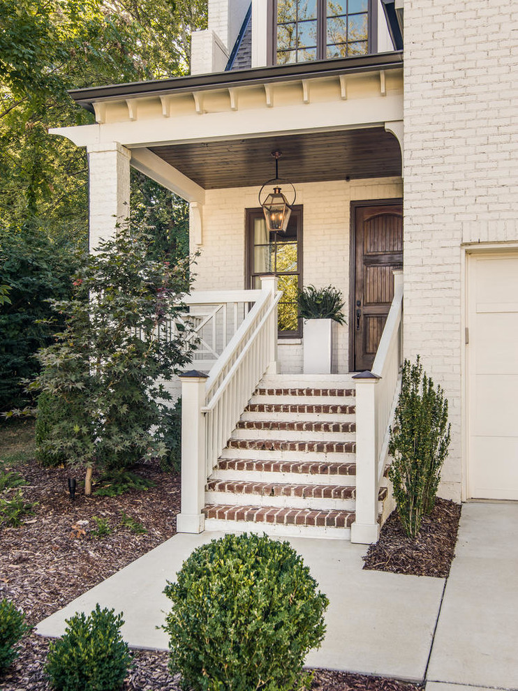 This is an example of a traditional front door in Nashville with white walls, a single front door and a dark wood front door.
