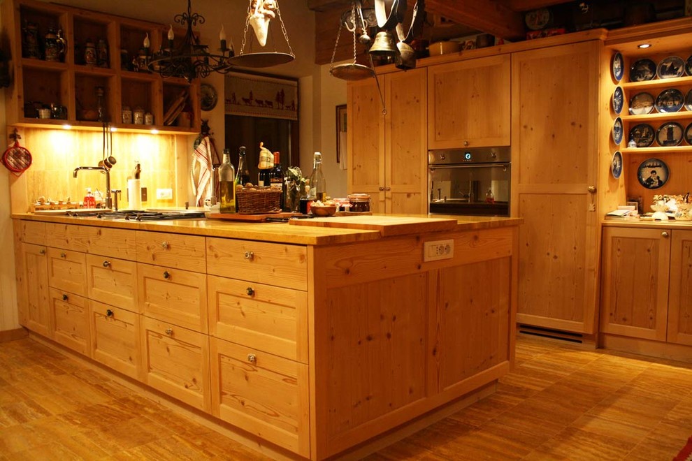 Example of a mid-sized mountain style galley marble floor open concept kitchen design in Milan with an undermount sink, beaded inset cabinets, light wood cabinets, paneled appliances and an island