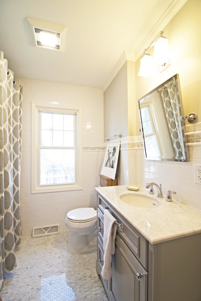 Design ideas for a mid-sized traditional kids bathroom in Chicago with an undermount sink, furniture-like cabinets, grey cabinets, marble benchtops, an alcove tub, a shower/bathtub combo, a two-piece toilet, white tile, ceramic tile, grey walls and mosaic tile floors.