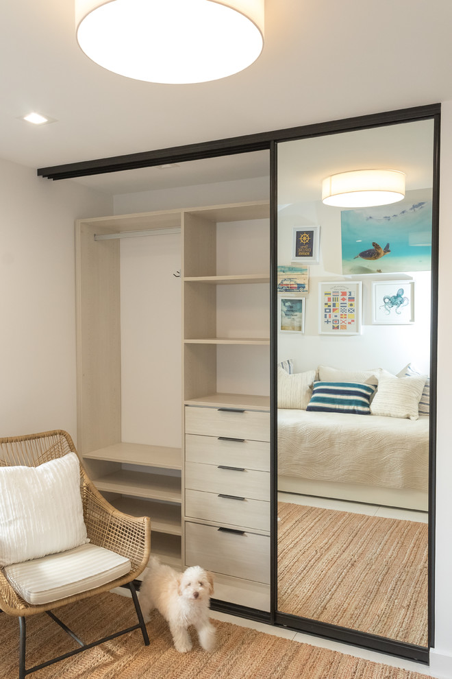 Photo of a mid-sized beach style loft-style bedroom in Other with white walls, porcelain floors and white floor.