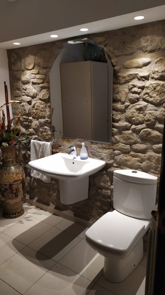 Inspiration pour un WC et toilettes chalet en bois vieilli de taille moyenne avec un placard sans porte, un carrelage de pierre, un lavabo suspendu, un plan de toilette blanc, meuble-lavabo encastré et un plafond voûté.