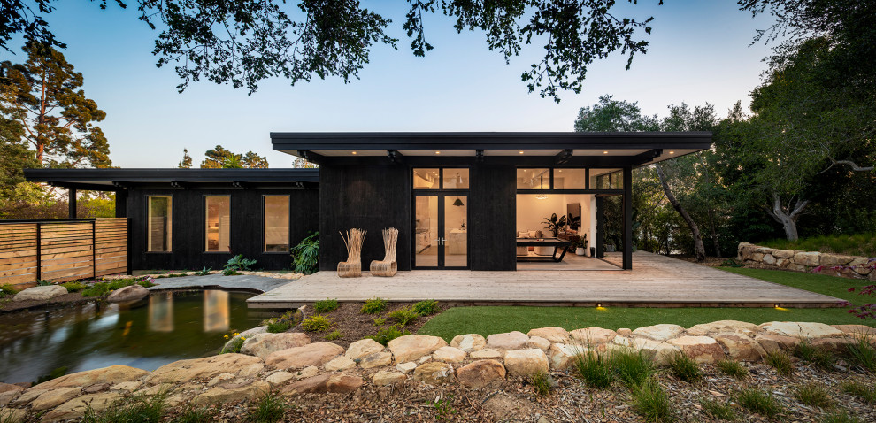 Diseño de fachada de casa negra vintage de tamaño medio de una planta con tejado plano
