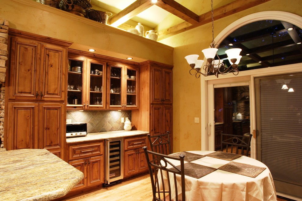 Example of a mountain style eat-in kitchen design in St Louis with an undermount sink, raised-panel cabinets, medium tone wood cabinets, granite countertops and stainless steel appliances