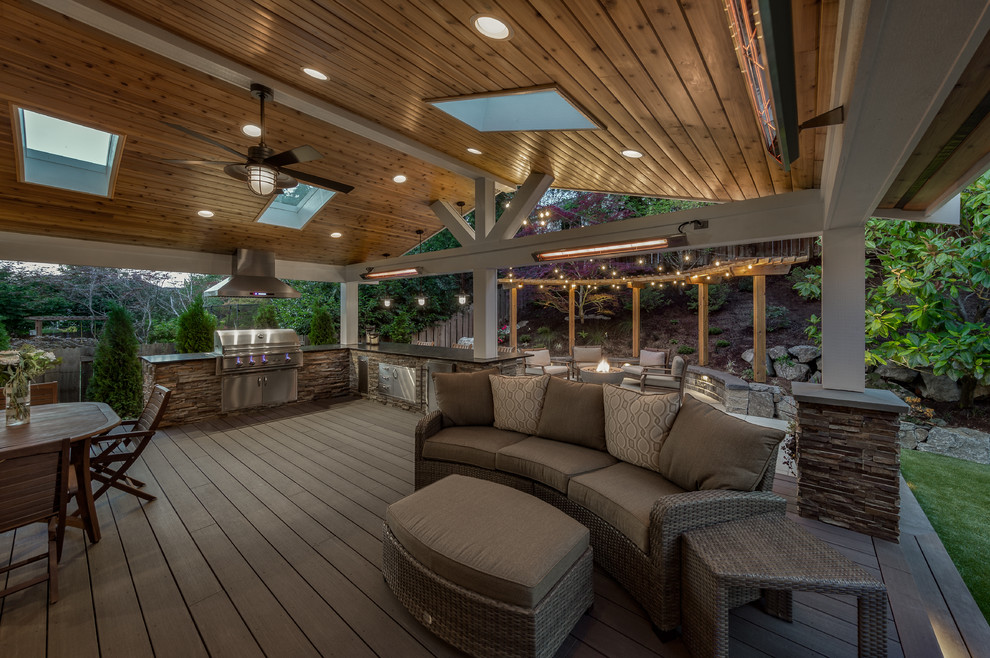 Photo of a large transitional backyard deck in Seattle with an outdoor kitchen and a roof extension.