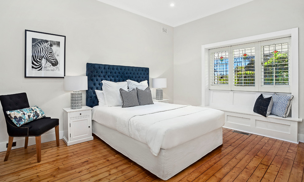 Inspiration for a mid-sized transitional master bedroom in Sydney with beige walls and medium hardwood floors.