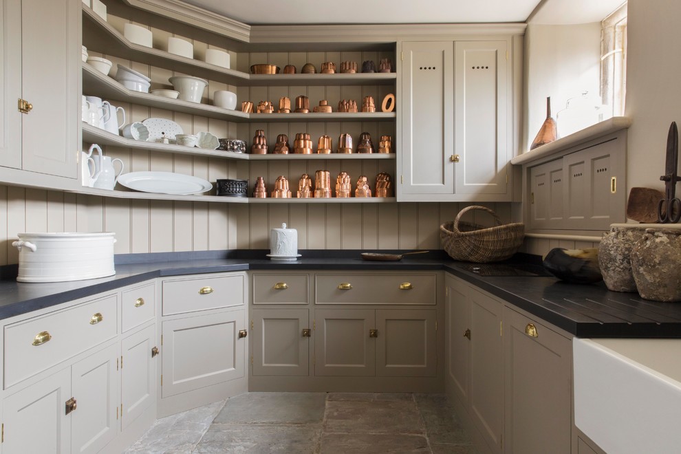 Inspiration for a country u-shaped kitchen pantry in London with a farmhouse sink, shaker cabinets, beige cabinets, beige splashback, timber splashback, no island and grey floor.