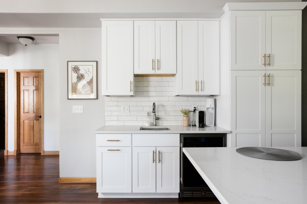 Eat-in kitchen - large transitional u-shaped dark wood floor eat-in kitchen idea in Denver with an undermount sink, shaker cabinets, white cabinets, quartz countertops, white backsplash, porcelain backsplash, stainless steel appliances, an island and white countertops
