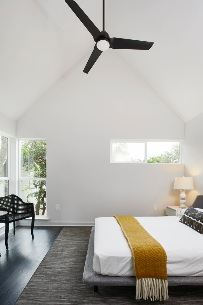 Photo of a contemporary master bedroom in Austin with white walls and dark hardwood floors.