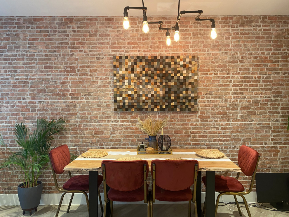 Aménagement d'une grande salle à manger ouverte sur la cuisine industrielle avec un mur multicolore, un sol en vinyl, cheminée suspendue, un manteau de cheminée en béton, un sol gris et un mur en parement de brique.