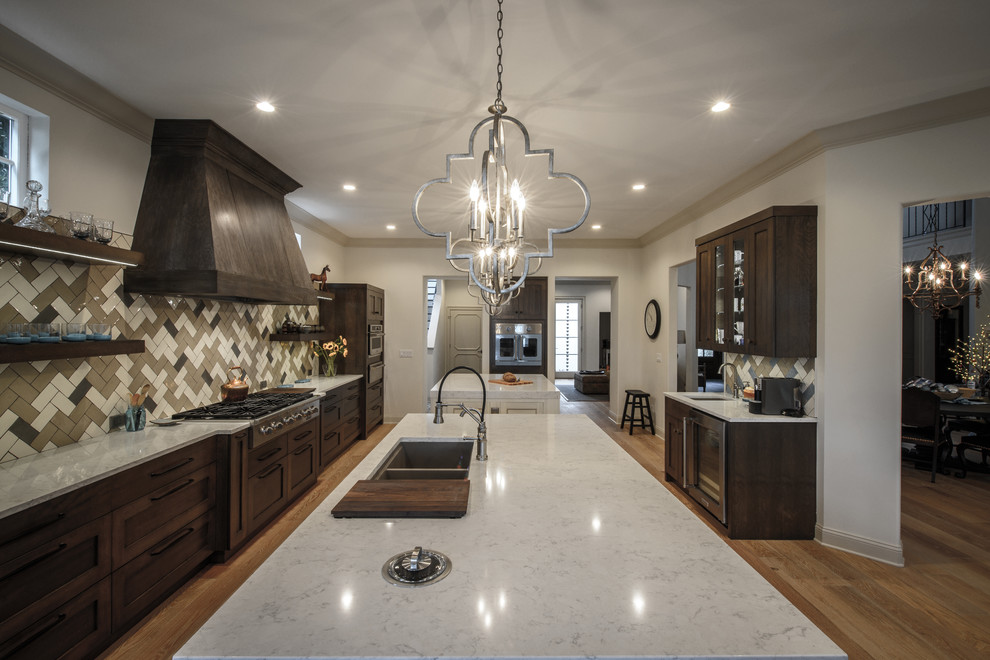 Large transitional galley light wood floor kitchen photo in Jacksonville with a double-bowl sink, shaker cabinets, dark wood cabinets, quartz countertops, brown backsplash, ceramic backsplash, stainless steel appliances and two islands