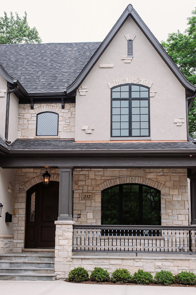 This is an example of a large traditional two-storey beige exterior in Chicago with mixed siding and a clipped gable roof.