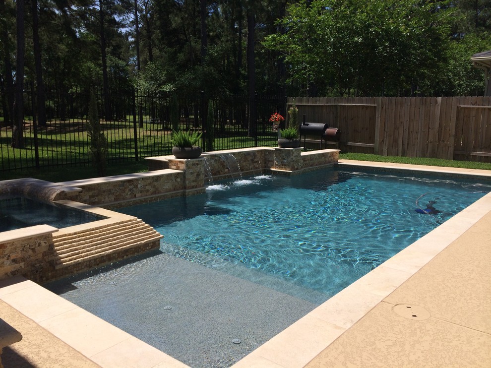 Inspiration for a mid-sized traditional backyard rectangular pool in Houston with concrete slab.