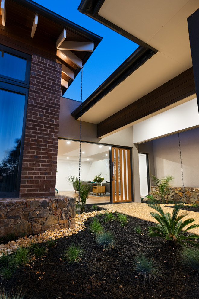 Photo of a large contemporary two-storey brick exterior in Melbourne with a hip roof.