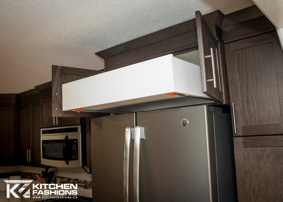 Example of a mid-sized transitional l-shaped enclosed kitchen design in Toronto with an undermount sink, shaker cabinets, dark wood cabinets, quartz countertops, multicolored backsplash, subway tile backsplash, stainless steel appliances and an island