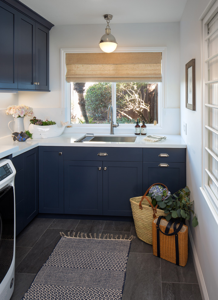 Inspiration for a classic l-shaped separated utility room in San Diego with a built-in sink, shaker cabinets, blue cabinets, engineered stone countertops, white splashback, engineered quartz splashback, white walls, porcelain flooring, a side by side washer and dryer, grey floors and white worktops.