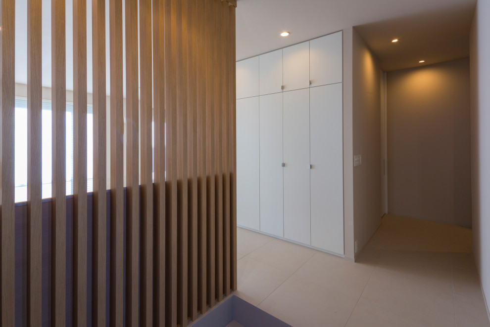 Immagine di un grande corridoio minimalista con pareti grigie, pavimento con piastrelle in ceramica, pavimento grigio, soffitto in carta da parati e carta da parati