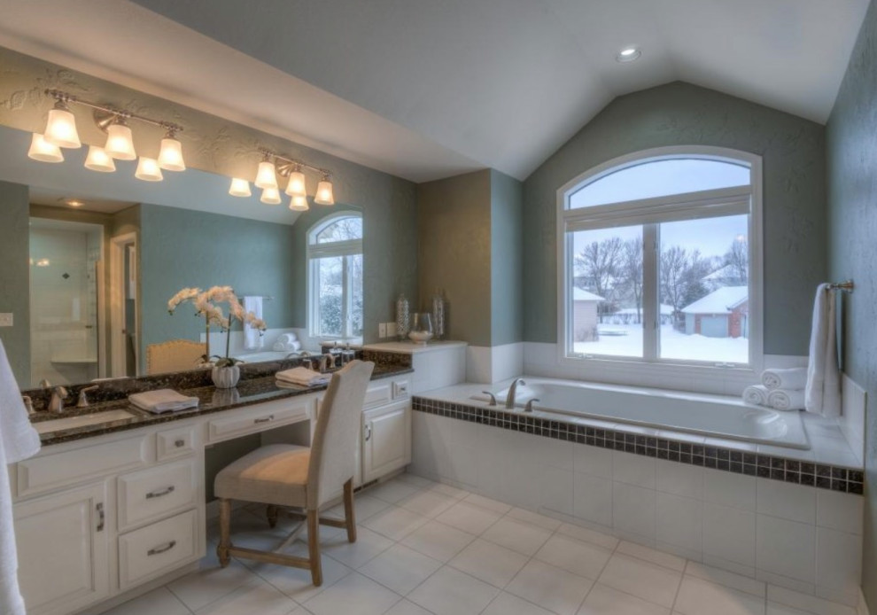 Photo of a large transitional master bathroom in Minneapolis with white cabinets, a hot tub, a one-piece toilet, black benchtops, a double vanity and a built-in vanity.