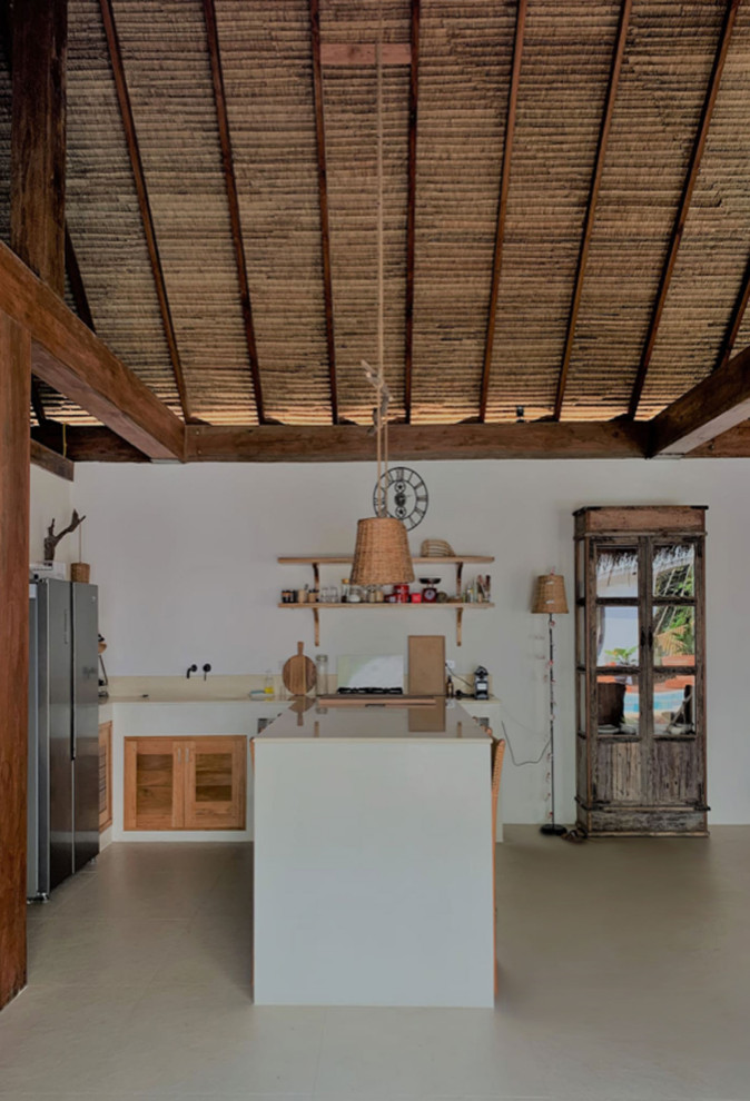 Bild på ett litet tropiskt vit vitt kök, med en undermonterad diskho, luckor med lamellpanel, vita skåp, bänkskiva i betong, beige stänkskydd, rostfria vitvaror, betonggolv, en köksö och beiget golv