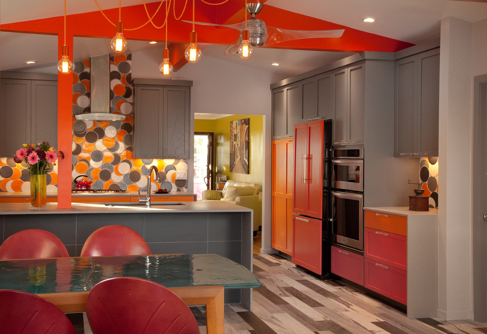 Inspiration for a mid-sized modern galley eat-in kitchen in Other with an undermount sink, shaker cabinets, orange cabinets, quartz benchtops, orange splashback, ceramic splashback, stainless steel appliances, porcelain floors and a peninsula.