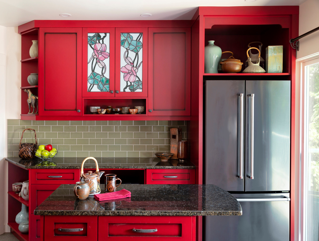 おしゃれなキッチン (緑のキッチンパネル、赤いキャビネット) の画像