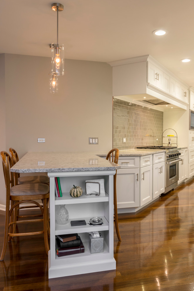 Inspiration for a mid-sized transitional galley medium tone wood floor eat-in kitchen remodel in Chicago with an undermount sink, flat-panel cabinets, white cabinets, quartz countertops, beige backsplash, glass tile backsplash, paneled appliances and a peninsula