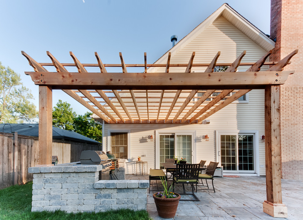 Design ideas for a traditional backyard patio in Chicago with an outdoor kitchen and a pergola.