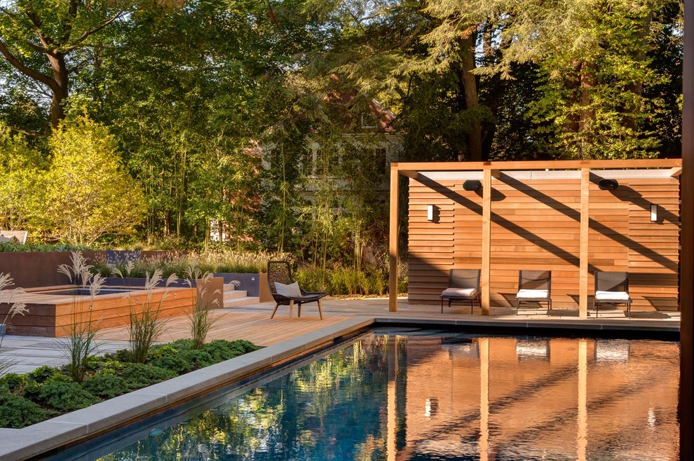 This is an example of a contemporary rectangular pool in Boston with a hot tub and decking.