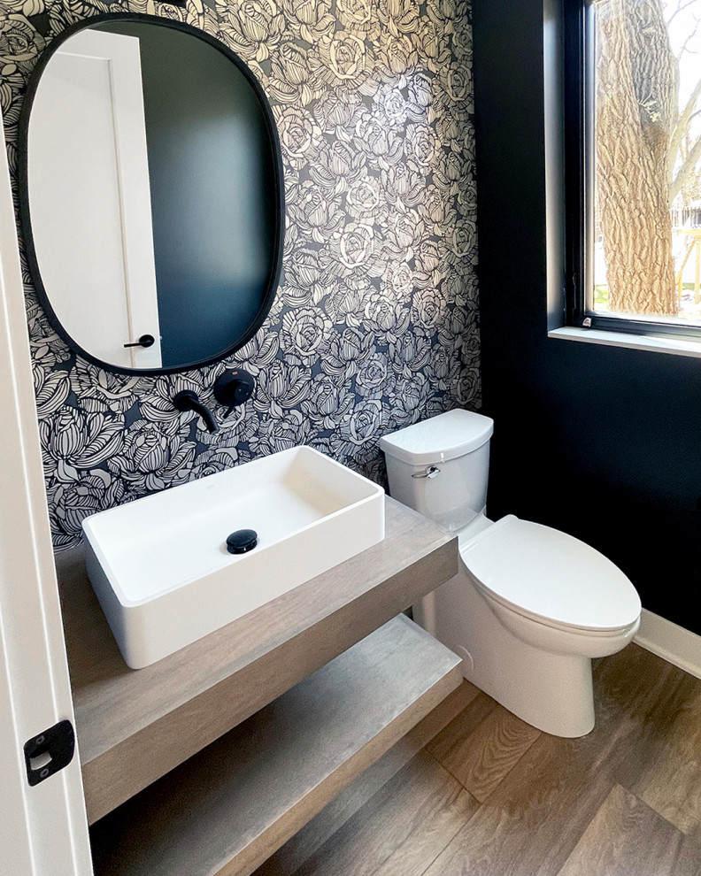 Foto de cuarto de baño único y flotante moderno pequeño con sanitario de una pieza, paredes negras, suelo de madera en tonos medios, lavabo sobreencimera, encimera de madera, suelo marrón, encimeras marrones y papel pintado