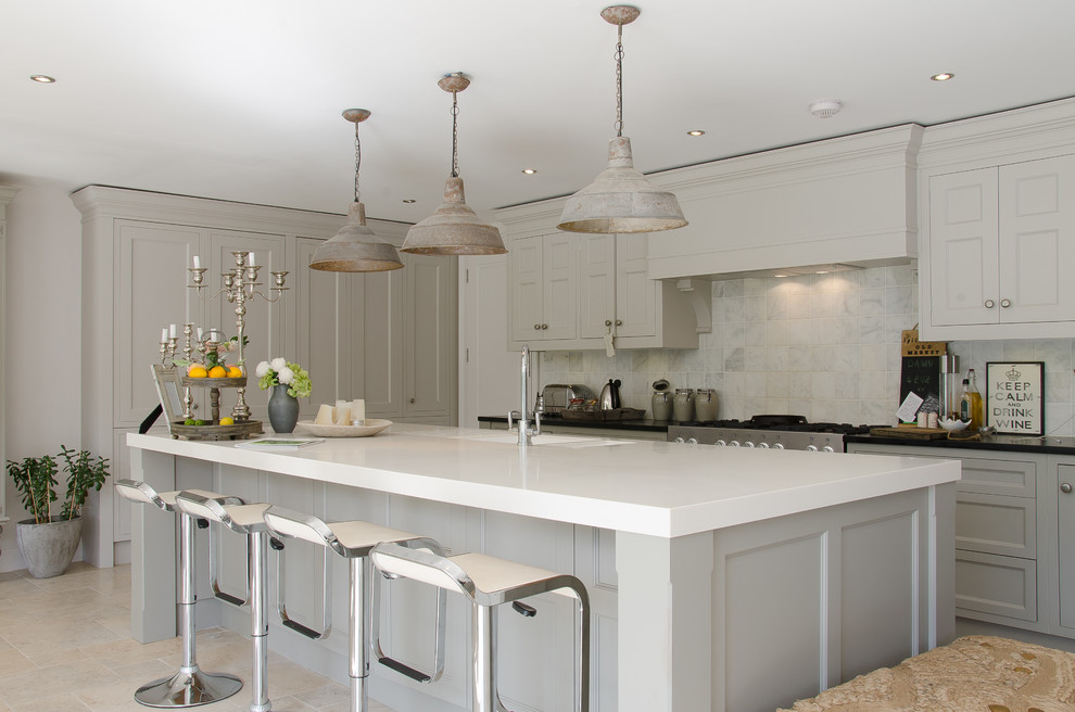 Transitional open plan kitchen in Surrey with an integrated sink, recessed-panel cabinets, grey cabinets, stainless steel appliances and with island.
