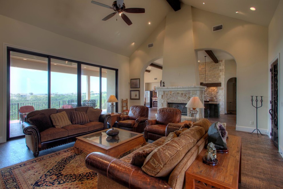 Design ideas for a country living room in Austin with dark hardwood floors and a stone fireplace surround.