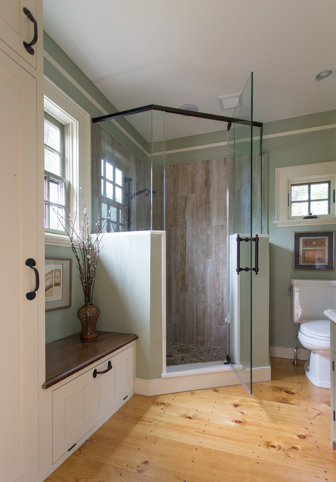 This is an example of a small country master bathroom in Boston with a vessel sink, beaded inset cabinets, white cabinets, an alcove shower, brown tile, green walls and light hardwood floors.