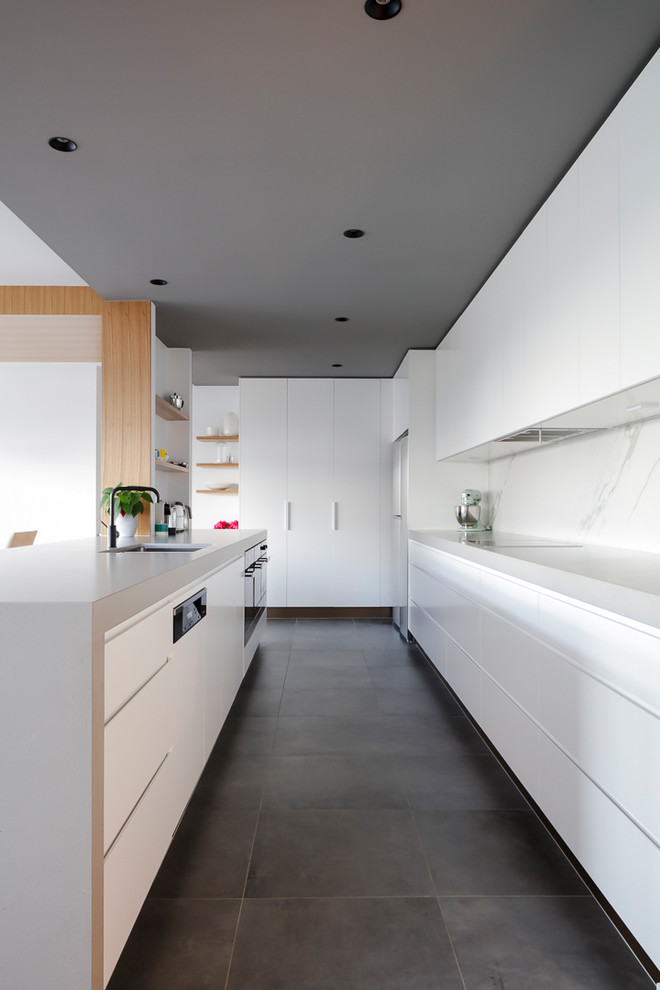 Inspiration for a contemporary kitchen in Sydney with an undermount sink, flat-panel cabinets, white cabinets, white splashback, stone slab splashback, grey floor and grey benchtop.