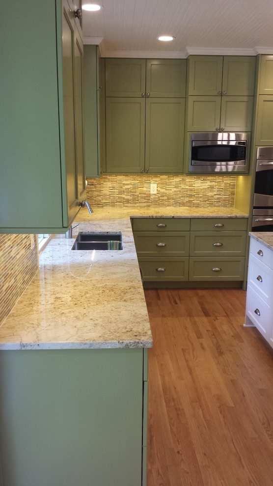 Kitchen - large transitional u-shaped medium tone wood floor kitchen idea in Seattle with a double-bowl sink, recessed-panel cabinets, white cabinets, granite countertops, multicolored backsplash, mosaic tile backsplash, stainless steel appliances and an island