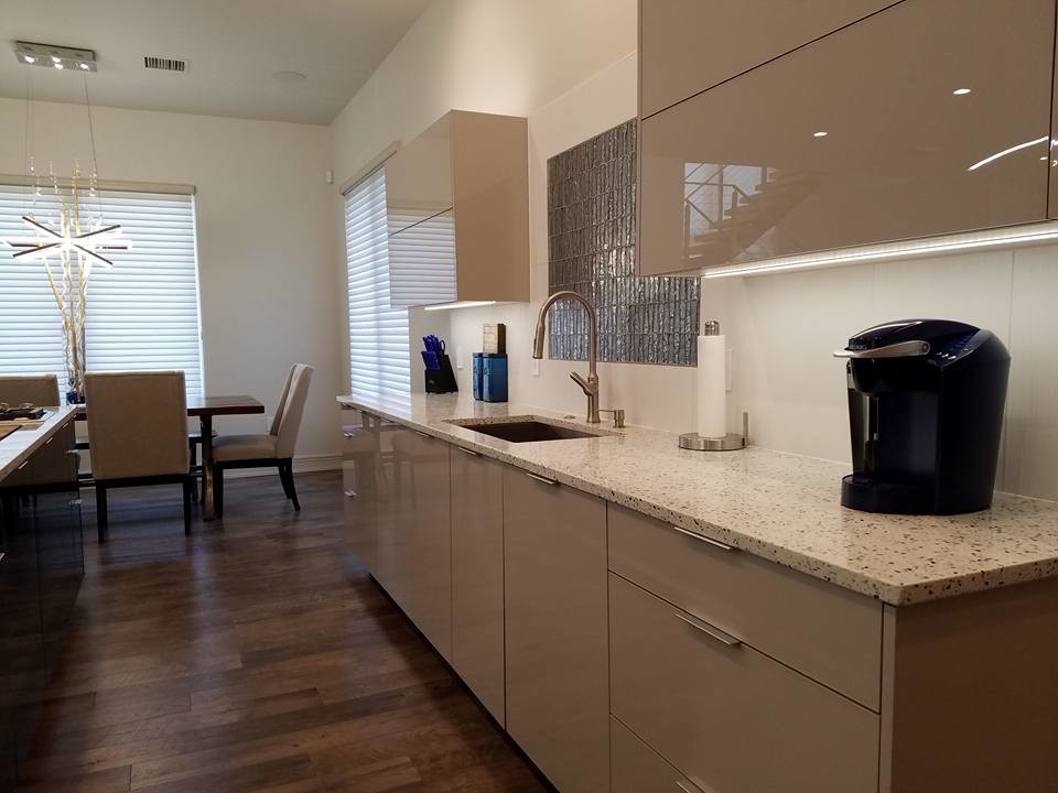 Lake House Dream - Close up of the kitchen working and focal wall. Complete with one basin stainless steel sink, stainless faucet, back splash mosaic, quartz counter tops and luxury vinyl tile that looks like reclaimed wood.