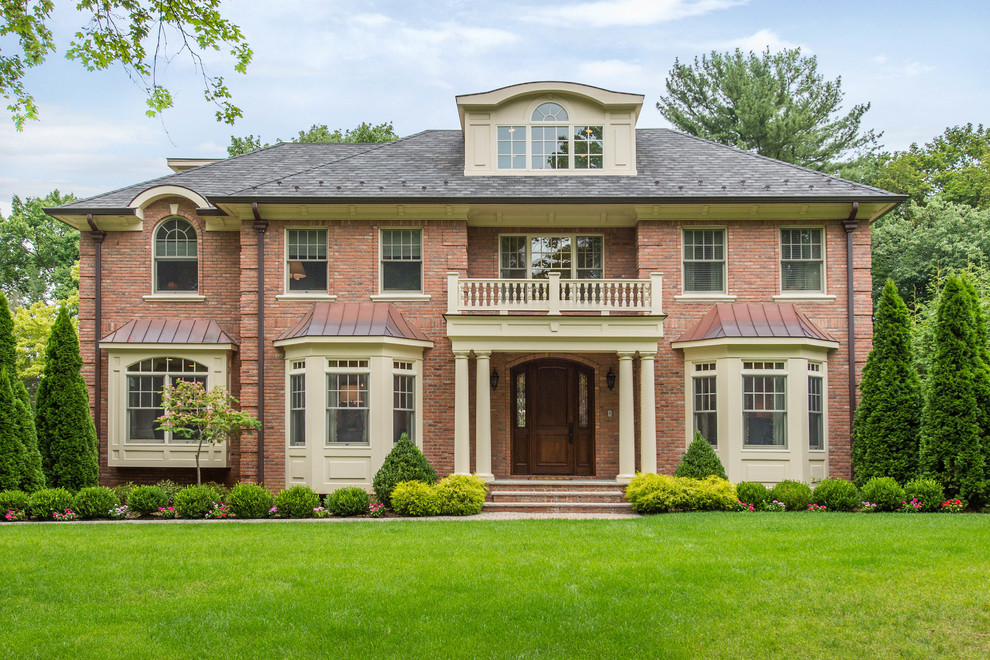 This is an example of an expansive traditional two-storey brick red house exterior in New York with a shingle roof and a hip roof.