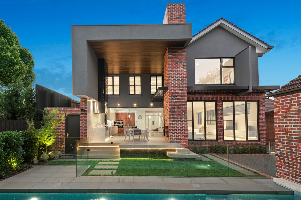 Design ideas for a large contemporary two-storey brick red exterior in Melbourne with a gable roof.