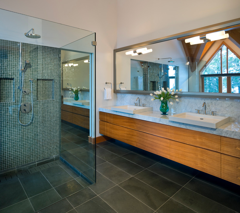 This is an example of a mid-sized contemporary master bathroom in Vancouver with mosaic tile, flat-panel cabinets, medium wood cabinets, a curbless shower, a vessel sink and a hinged shower door.