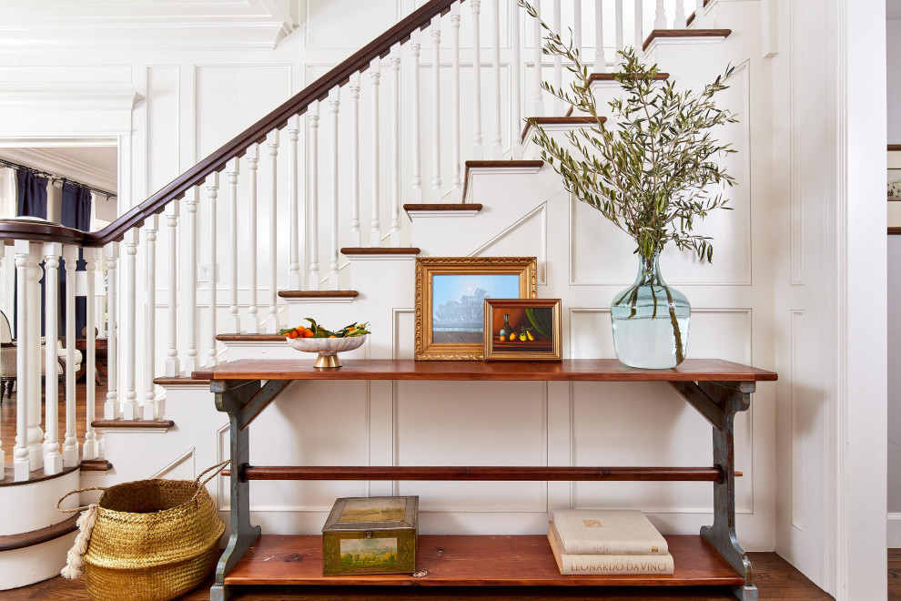 Photo of a large traditional wood l-shaped staircase in San Francisco with painted wood risers, wood railing and panelled walls.