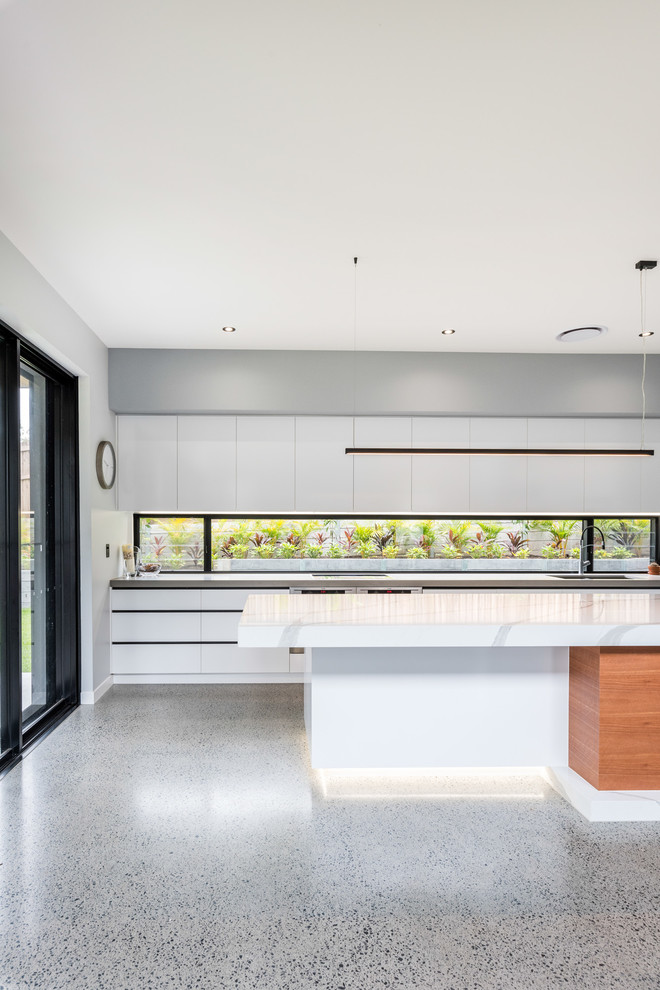 This is an example of a contemporary kitchen in Brisbane with an undermount sink, flat-panel cabinets, white cabinets, concrete benchtops, window splashback, concrete floors, with island, grey floor and grey benchtop.