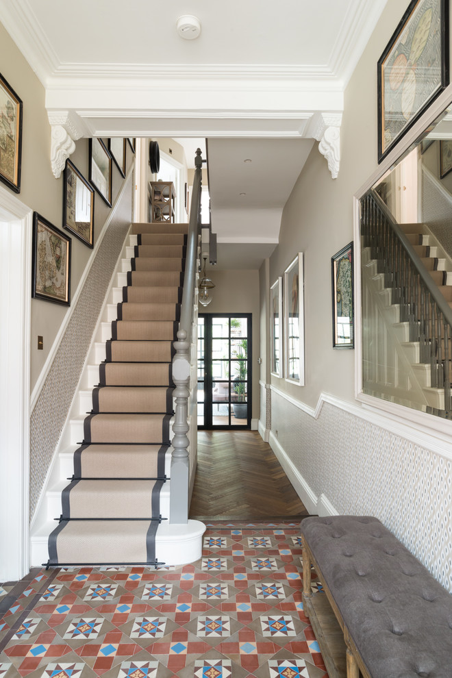 This is an example of a large transitional hallway in London with beige walls, porcelain floors and multi-coloured floor.