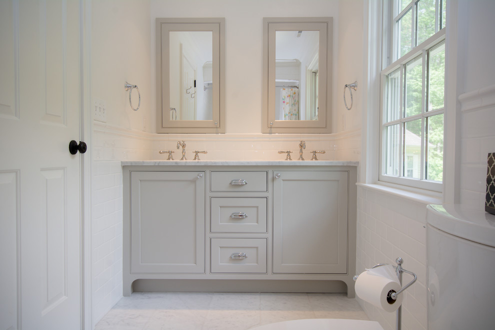 Photo of a mid-sized traditional kids bathroom in New York with an undermount sink, grey cabinets, marble benchtops, an alcove tub, a shower/bathtub combo, a two-piece toilet, white tile, subway tile, white walls, marble floors and recessed-panel cabinets.