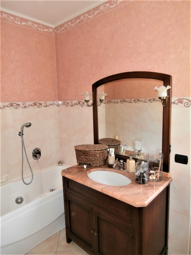 Design ideas for a traditional bathroom in Other with furniture-like cabinets, dark wood cabinets, a hot tub, pink walls, porcelain floors, marble benchtops, pink floor and pink benchtops.