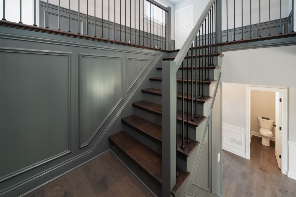 Inspiration for an arts and crafts wood u-shaped staircase in Louisville with wood risers, wood railing and decorative wall panelling.