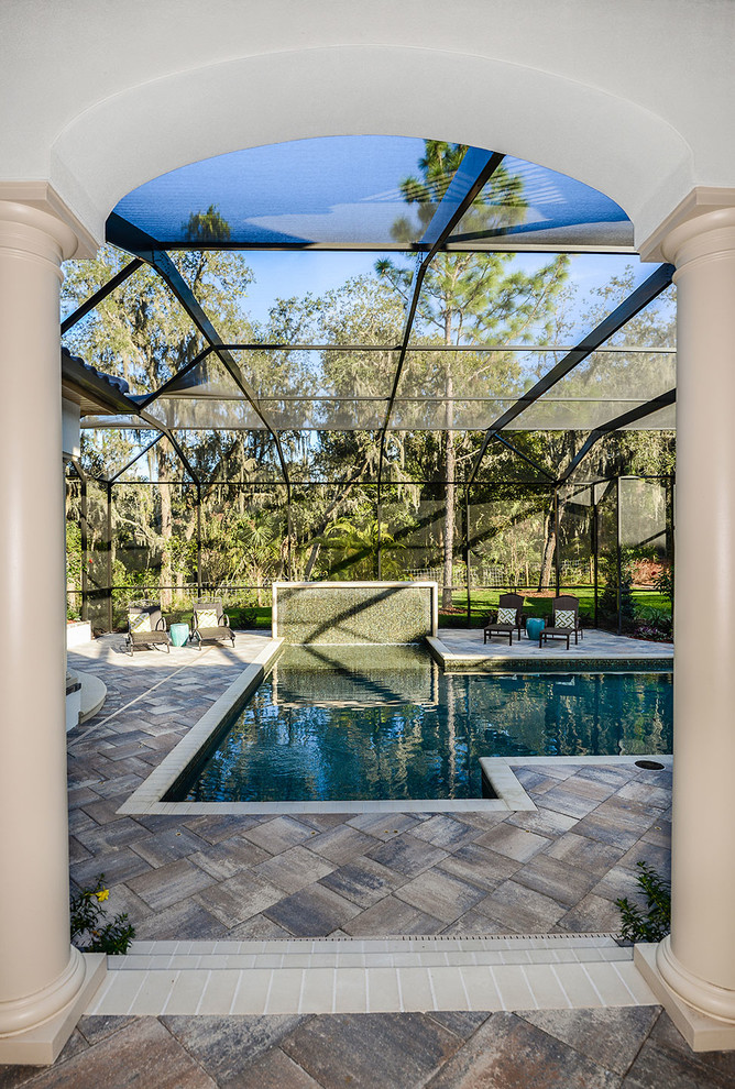 Inspiration for a mediterranean indoor custom-shaped pool in Tampa with a water feature.