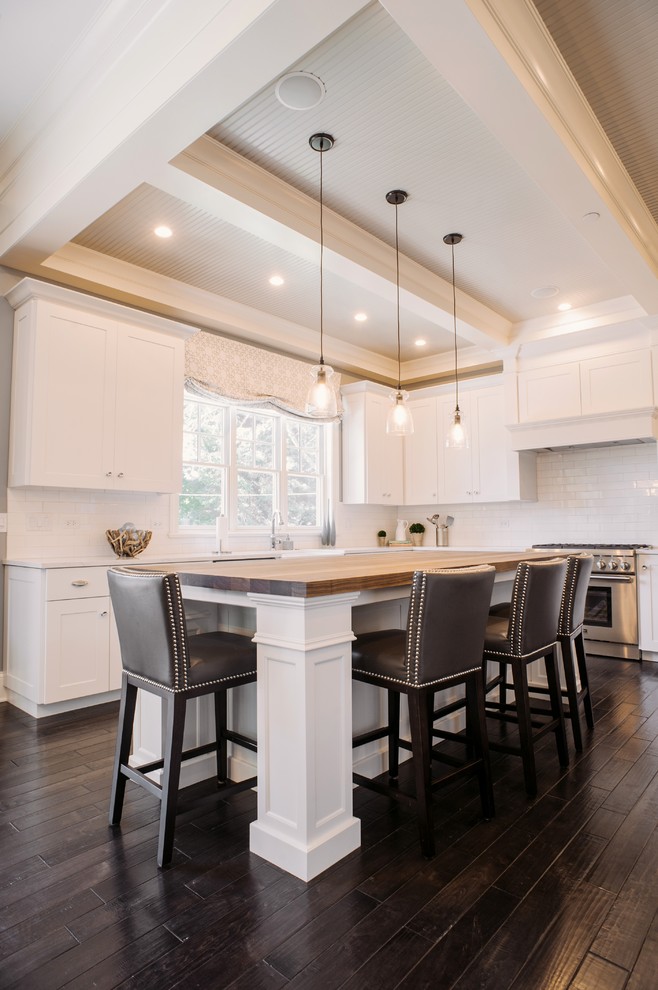 This is an example of a transitional kitchen in Chicago with recessed-panel cabinets, white cabinets, white splashback, subway tile splashback and stainless steel appliances.