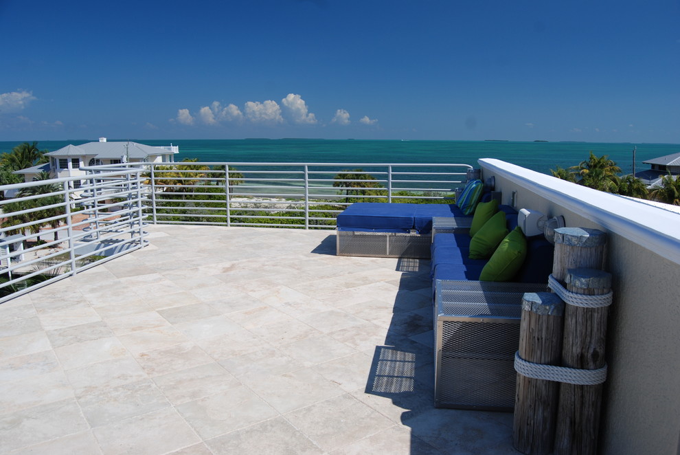 This is an example of a large tropical patio in Miami with tile and no cover.