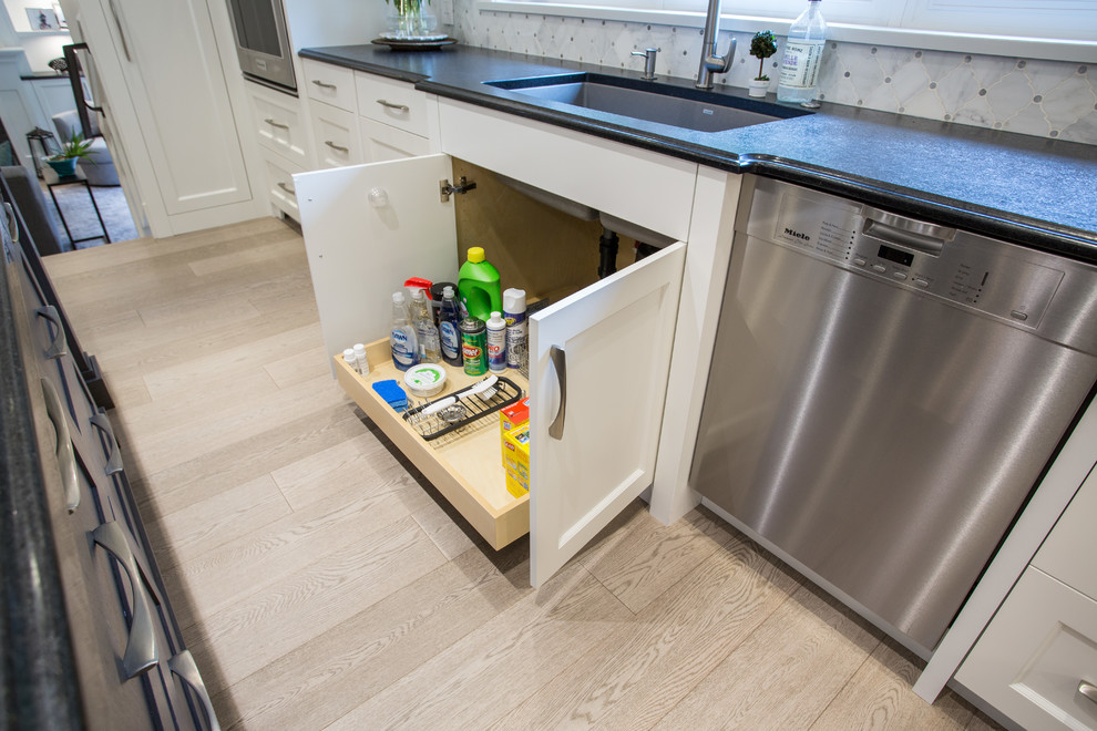 Inspiration for a large transitional l-shaped medium tone wood floor and beige floor eat-in kitchen remodel in Vancouver with an undermount sink, shaker cabinets, white cabinets, granite countertops, gray backsplash, marble backsplash, stainless steel appliances, an island and black countertops