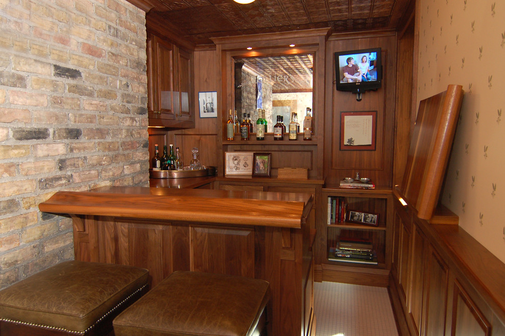 Design ideas for a mid-sized traditional single-wall seated home bar in Minneapolis with raised-panel cabinets, dark wood cabinets, wood benchtops, brown splashback, timber splashback and brown benchtop.