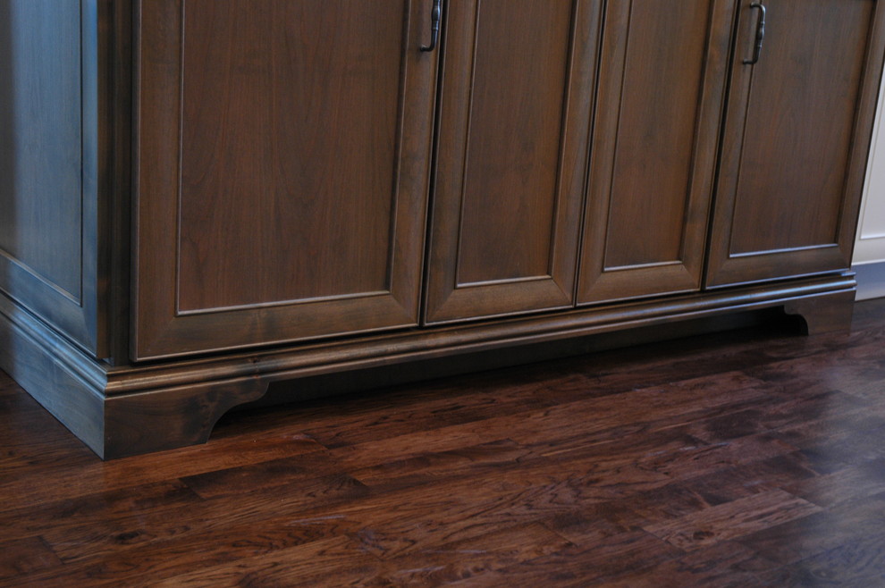 Inspiration for a large transitional u-shaped medium tone wood floor kitchen pantry remodel with a farmhouse sink, flat-panel cabinets, white cabinets, granite countertops, brown backsplash, stone tile backsplash, paneled appliances and an island