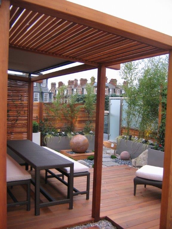 Inspiration for a mid-sized contemporary rooftop deck in London with a water feature and a pergola.